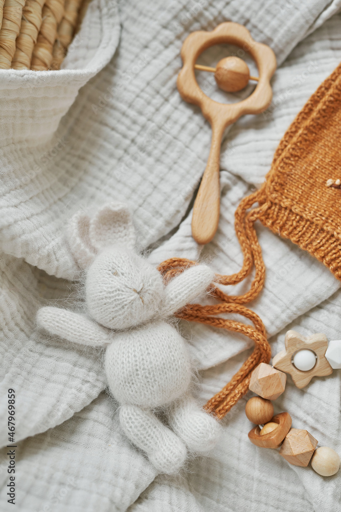 Fototapeta premium Hobbies and handicrafts. Knitted beanie with handmade embroidery. Wooden toys, rattles, teethers, nipple holder. Baby development, fine motor skills. Children and newborn products and accessories.