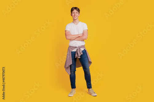 Full body photo of young cheerful guy good mood confident crossed hands isolated over yellow color background