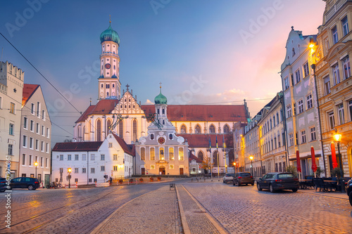 Augsburg, Germany. Cityscape image of old town street of Augsburg, Germany with the Basilica of St. Ulrich and Afra at autumn sunset. photo