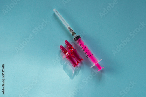 Wallpaper Mural Pink medicine in ampoules (vitamin B) and a pink syringe on a blue background. Ampoules for injections.  Torontodigital.ca