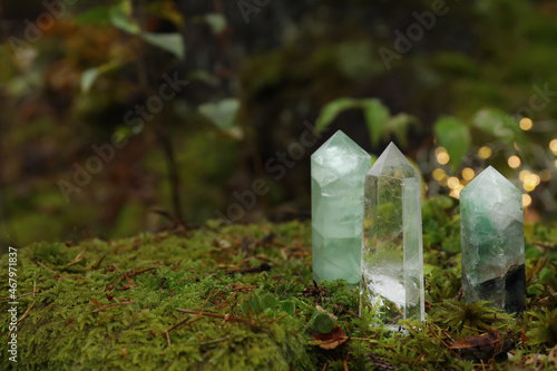 Different crystals on moss against blurred lights, space for text