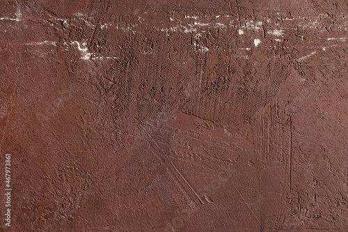 Red scratched and weathered plaster on concrete wall texture. Abstract background