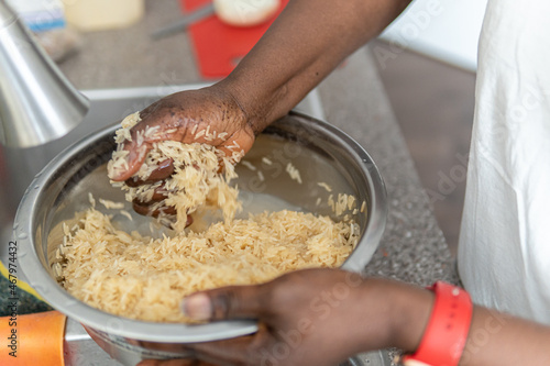 African American Nigerian woman washing rice before cooking