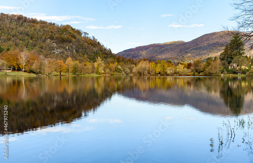 Autumn landscape of Lake Ghirla with colorful trees and reflection in the water, Valganna, province of Varese, Italy