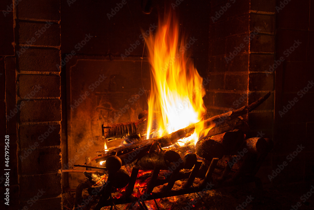 bright flame of fire burns in a fireplace in the old house in winter evening bright flame of fire burns in a fireplace in the old house in winter evening
