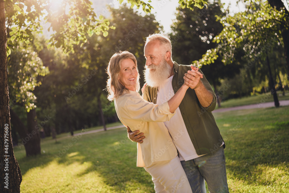 Obraz premium Portrait of attractive cheerful middle-aged couple life partners dancing spending free time vacation on fresh air outdoors