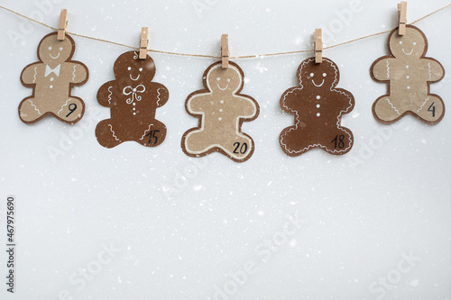 Christmas Advent calendar. Hanging on a rope, figures in the form of smiling gingerman cookies. Concept hobby, DIY. photo