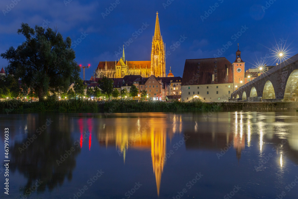 Regensburg. The old cathedral on the city embankment near the Danube river at night.
