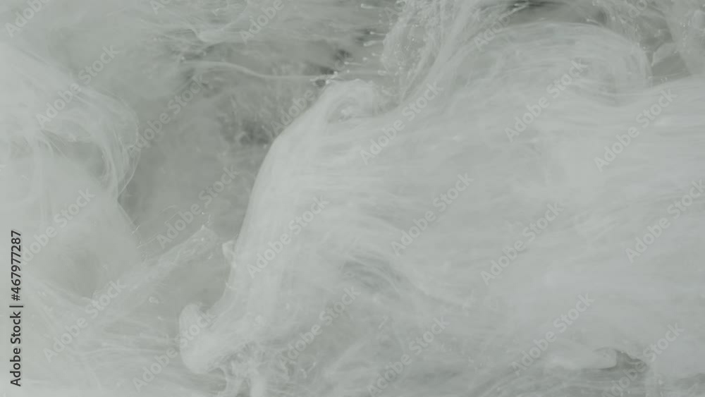 Beautiful screensaver. White abstract background. Slow motion of waves of milky ink mixing with each other in water. White watercolor ink in water. Beautiful screensaver. White abstract background. Slow motion of waves of milky ink mixing with each other in water. White watercolor ink in water.