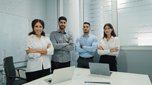 Smiling cheerful multicultural group posing with arms crossed feels happy, showing team spirit, support, strength. Business colleagues shooting for company ad. Concept of leadership, teamwork, unity