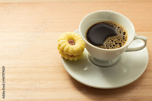 Uma xícara com café e um biscoito amanteigado. photo