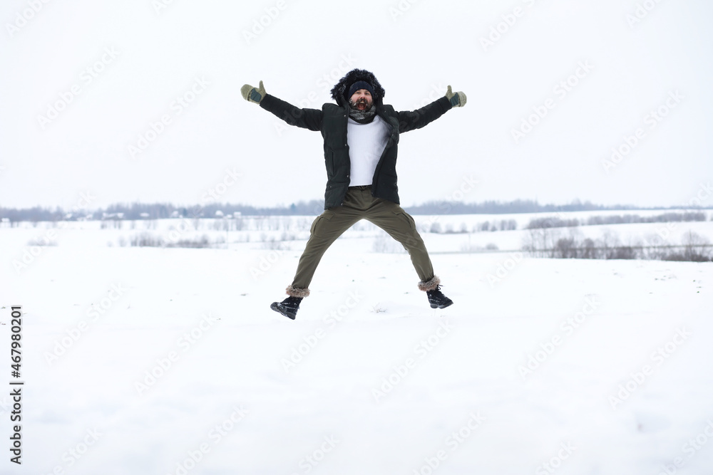 Bearded man in the winter woods. Attractive happy young man with beard walk in the park.