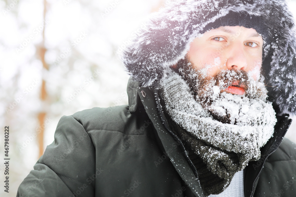 Outdoor portrait of handsome man in coat and scurf. Bearded man in the winter woods. Outdoor portrait of handsome man in coat and scurf. Bearded man in the winter woods.