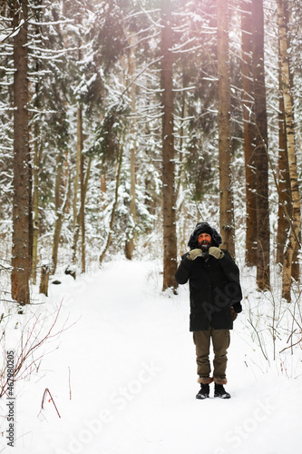 Outdoor portrait of handsome man in coat and scurf. Bearded man in the winter woods. © alexkich