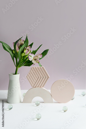 flowers in a vase with geometric objects. flowers in a vase on a light background.