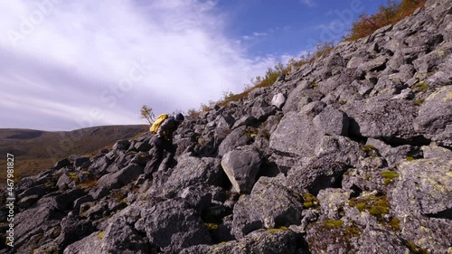 Tourist traveler with a backpack in the mountains. Khibiny mountains in an autumn day. Nice view of the mountains. Snow-capped mountain peaks in the sun