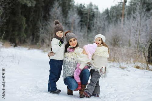 Happy family playing and laughing in winter outdoors in the snow. City park winter day.