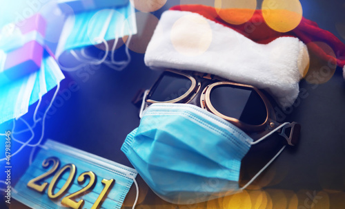 Christmas or New Year celebration concept. Santa Claus hat, glasses and nose with face mask on red background.