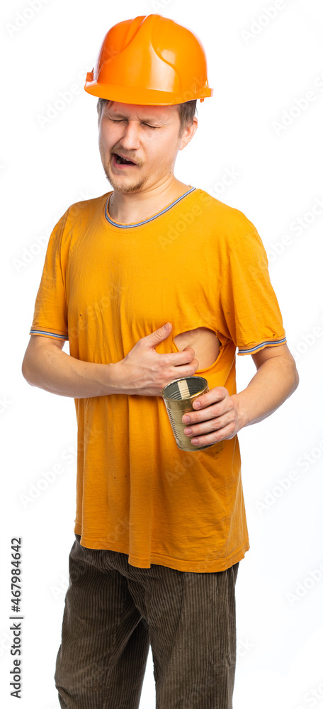a guy in old clothes, a man in an orange T-shirt, a hat on top of his head. a man in a construction helmet itches, yawns and holds an empty can. isolated white background a guy in old clothes, a man in an orange T-shirt, a hat on top of his head. a man in a construction helmet itches, yawns and holds an empty can. isolated white background