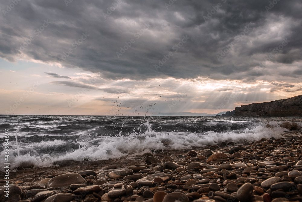 wild beach. sea ​​wave on a rocky shore. clouds over the sea