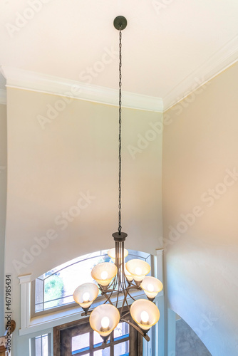 Shaded chandelier on the ceiling above the front door of a house