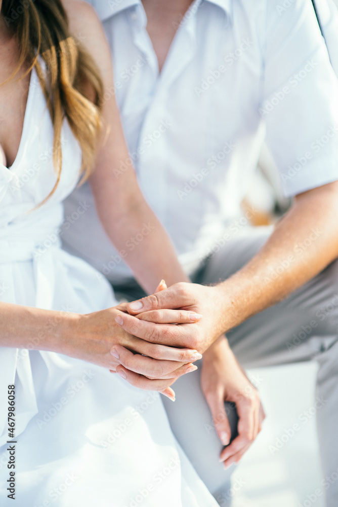 the bride and groom tenderly hold hands between them love the bride and groom tenderly hold hands between them love