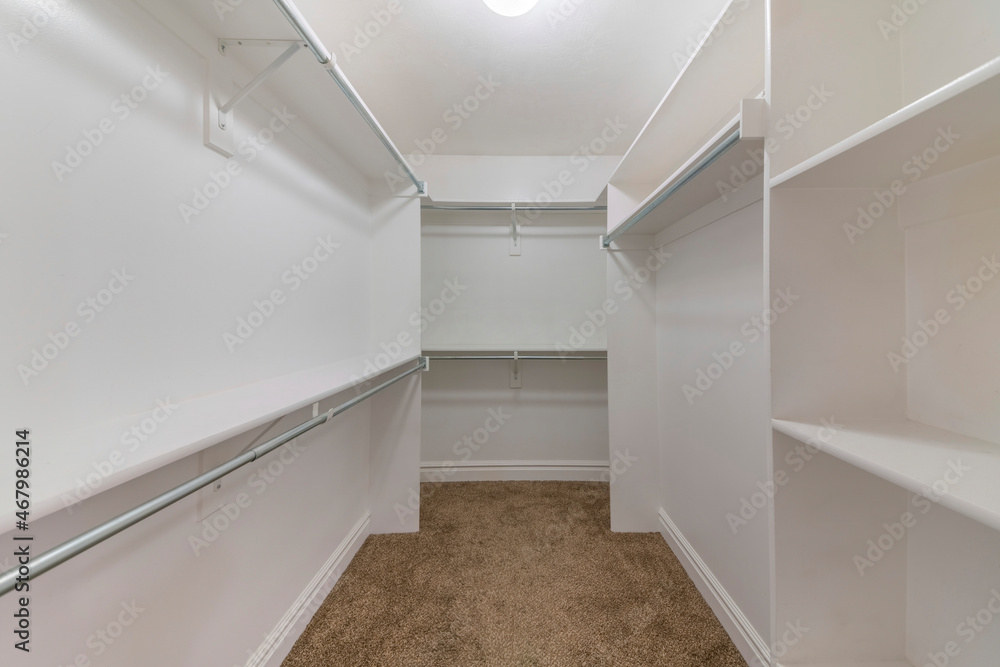 Empty walk-in closet shelving units with metal rods Empty walk-in closet shelving units with metal rods
