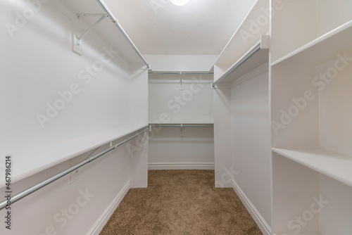 Empty walk-in closet shelving units with metal rods