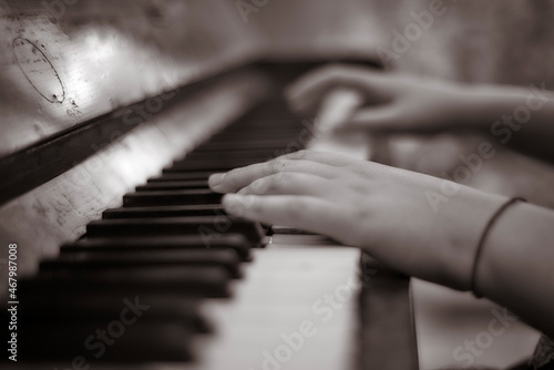 A teen girl plays the vintage piano in her room. Hands Close up. Young music player for lifestyle concept. Black and white.