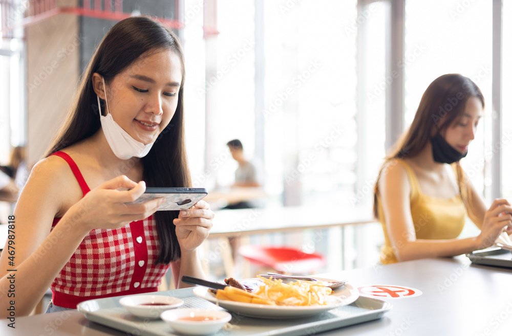 Young attractive asian teen female influencer, foodie blogger take photo of food .keep social distance for protect infection from coronavirus covid-19, restaurant and social distancing concept. Young attractive asian teen female influencer, foodie blogger take photo of food .keep social distance for protect infection from coronavirus covid-19, restaurant and social distancing concept.