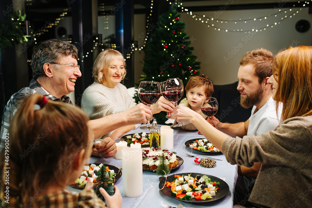 Lively big family on christmas gathering. Clinking wine glasses, celebrating