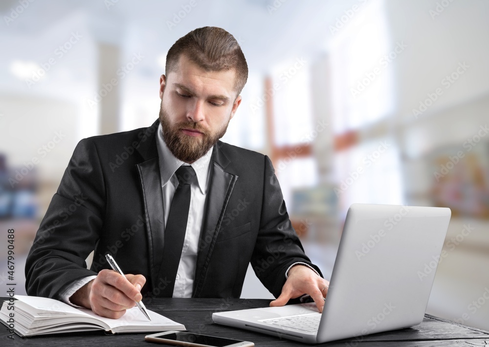 Happy mature executive manager using laptop writing notes Happy mature executive manager using laptop writing notes
