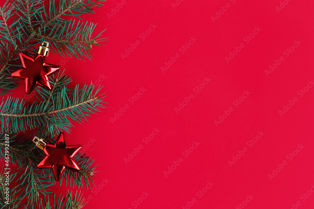 Christmas background with spruce branches and red ornaments.