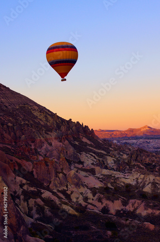 Air balloons festival in Cappadocia. Hot air balloon over the mountain. Picturesque nature landscape in the background. Colorful vibrant sky