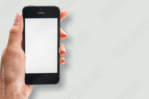 Male hand holding a smartphone with blank screen.