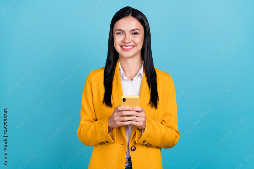Photo of positive attractive business woman hold hand telephone write message isolated on blue color background Photo of positive attractive business woman hold hand telephone write message isolated on blue color background