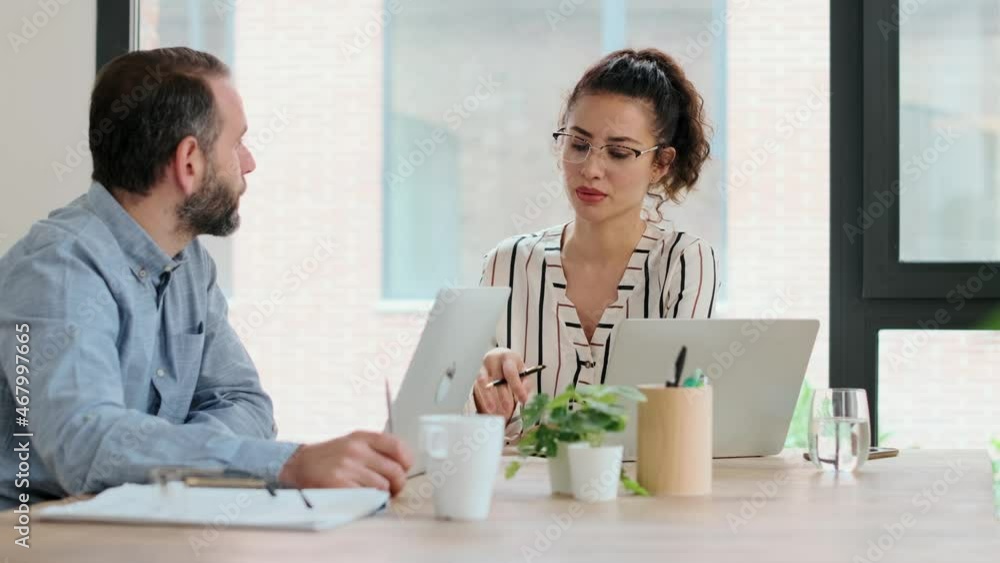 Video of smart business people working together with laptop while talking in the coworking place. Video of smart business people working together with laptop while talking in the coworking place.