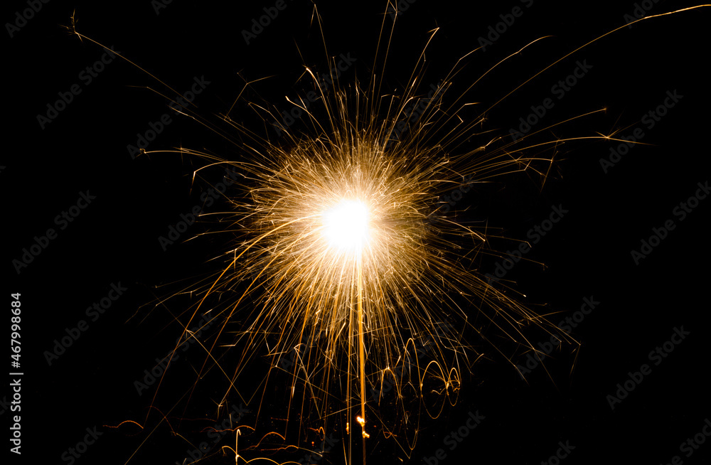 New Year's Eve celebration with a sparkler, isolated on black background.