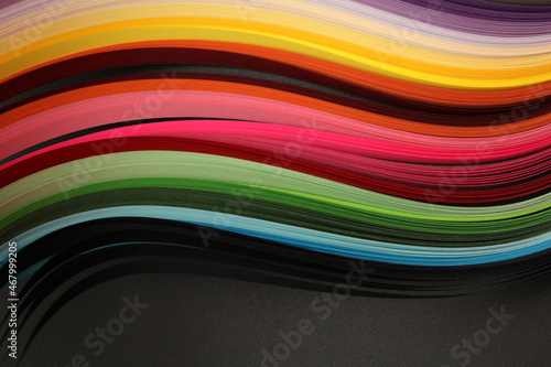 Abstract rainbow color wave paper on texture black horizontal background.
