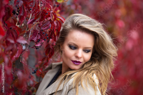 Portrait of stylish sexy woman with makeup and manicure in trench coat