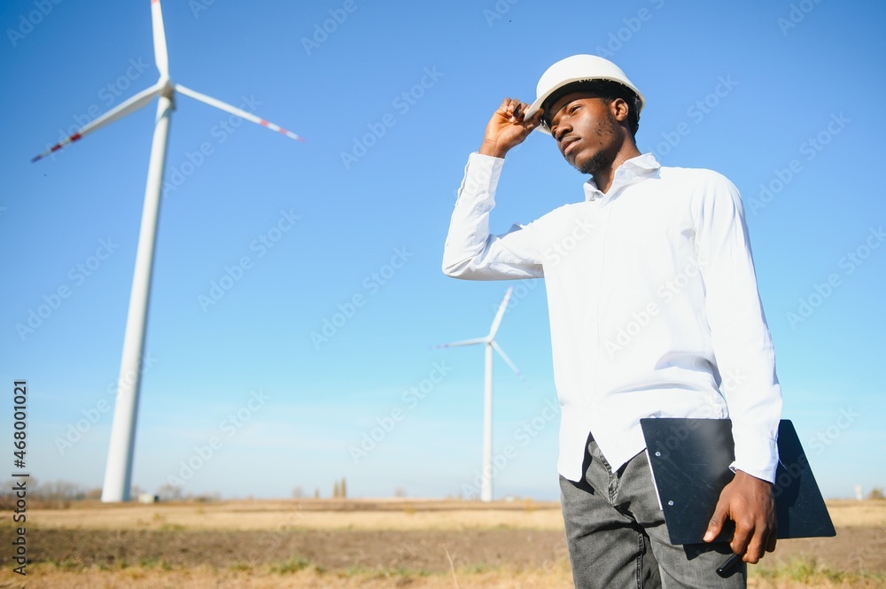Engineer African man standing with wind turbine Engineer African man standing with wind turbine