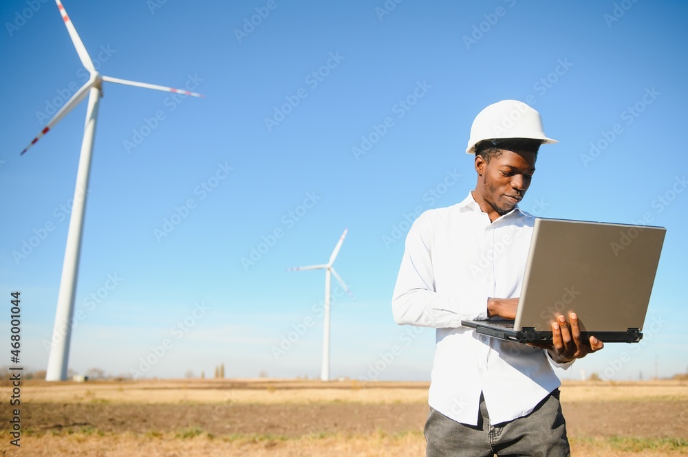 Engineer African man standing with wind turbine Engineer African man standing with wind turbine