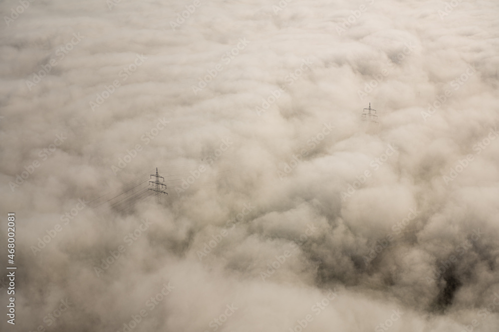 Luftaufnahme Strommasten ragen aus dem Nebel