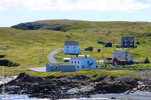 Traditional saltbox houses on the coast, Elliston, Newfoundland. Beach and coastline in foreground. photo