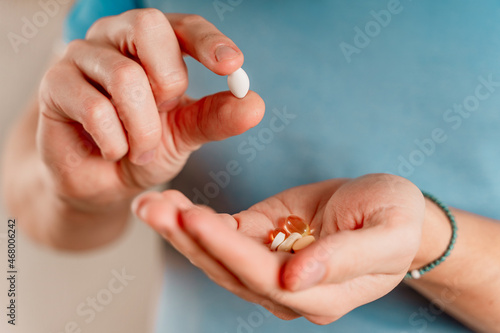 The man holds pills and capsules in his hand. Taking vitamins and medications, close up