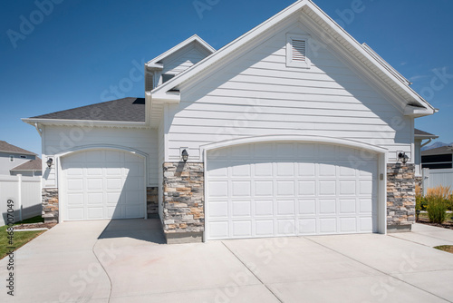 Three car garage exterior with two white garage doors with arched door openings