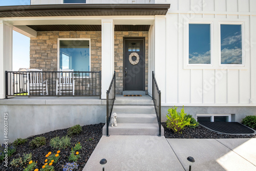 Facade of a house with stone veneer and white board and batten sidings