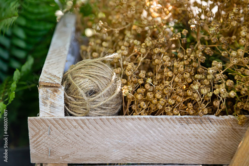 wooden box with twine and dried flowers. Needlework, hobby concept