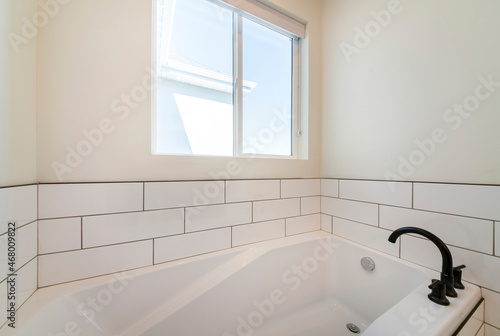 Alcove bathtub with white subway tiles surround with black grout