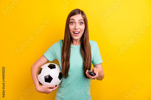 Photo of cool brunette hairdo millennial lady hold ball switch tv wear teal t-shirt isolated on yellow color background © deagreez